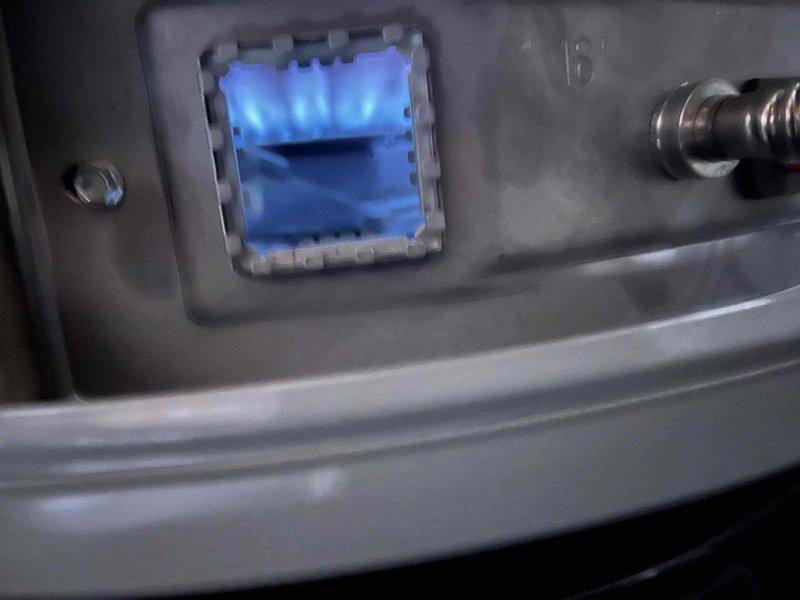 Responded to service call for dual water heater system where one unit's pilot light would not ignite, displaying thermopile low voltage error code upon attempted ignition. Diagnosed failed thermopile preventing pilot assembly from maintaining flame. Coordinated with warranty provider who approved tank replacement with customer responsible for two modifications (waterline and flue) and four code upgrades (shut-off valve, drain pan, T&P drain line, and expansion tank) per plan agreement exclusions. Documented existing State brand water heater installation with copper supply lines, expansion tank, and water treatment system. Photographed burner assembly showing proper blue flame characteristics on operational unit for comparison. Awaiting warranty coverage confirmation on replacement unit cost before proceeding with installation.