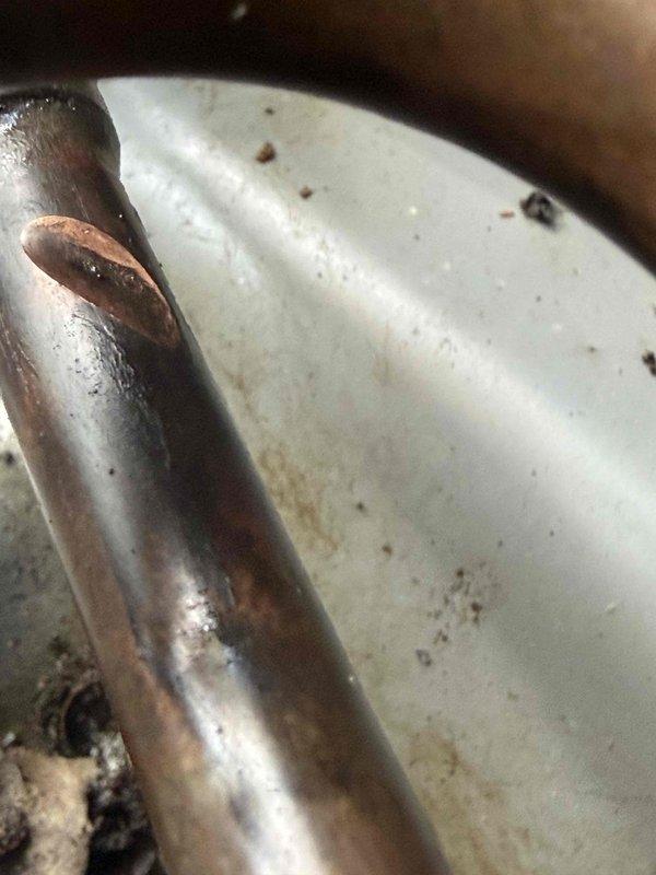 Responded to service call for attic-mounted air conditioning unit with non-operational condenser fan. Upon inspection, diagnosed failed dual run capacitor preventing fan motor operation. Replaced defective capacitor with manufacturer-specified component, restored proper fan function, and verified system cooling performance. Noted moderate debris accumulation around outdoor coil and copper refrigerant lines showing normal condensation during operation; recommended routine maintenance to prevent future airflow restrictions.