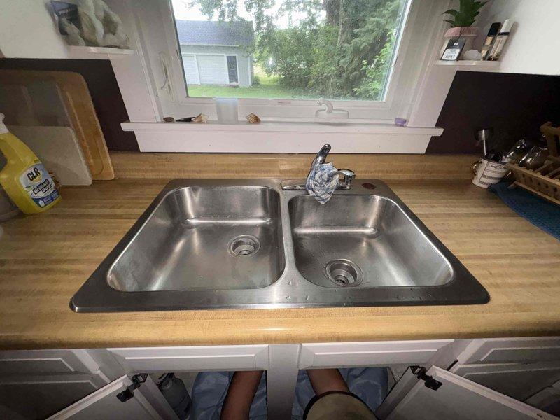Completed installation of new chrome single-handle faucet and drop-in stainless steel double-basin sink in residential kitchen. Replaced existing fixtures with like-for-like units, ensuring proper plumbing connections and verifying all supply lines and drain assemblies were secure and leak-free upon completion.