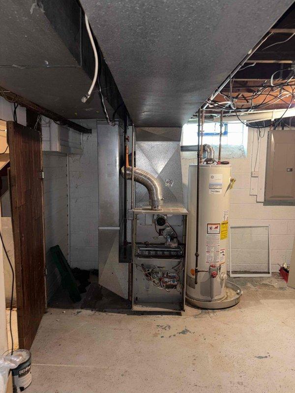 Conducted estimate for furnace replacement in basement mechanical room. Existing 20-year-old gas furnace evaluated and documented with photos showing unit configuration, ductwork connections, and electrical service panel with 100-amp main breaker. Customer expressed interest in financing options for new equipment installation.