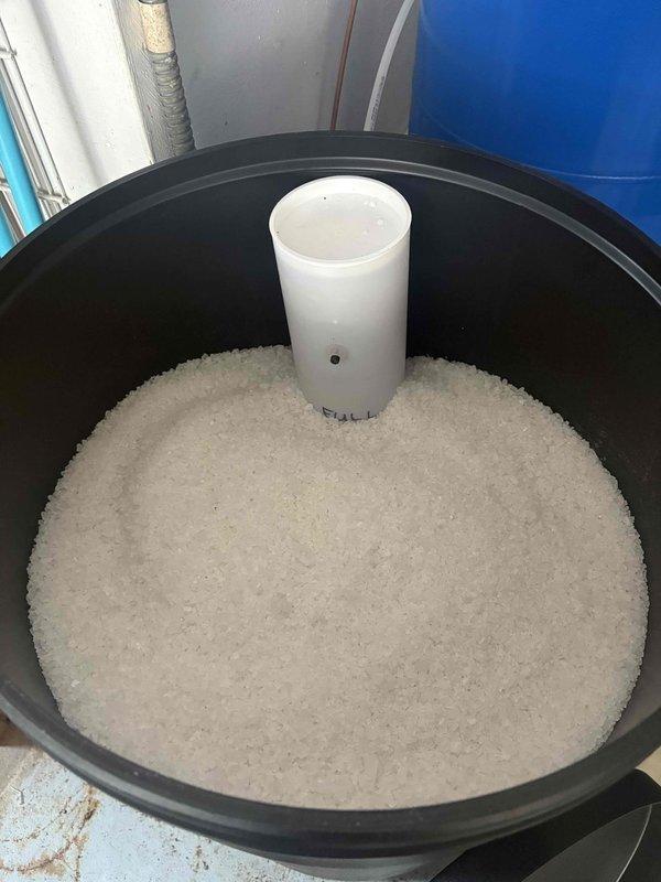Delivered four bags of solar salt to replenish water softener system that was running low on media. Verified salt product did not contain iron-out additive per customer requirements and loaded salt into brine tank to restore proper system operation.