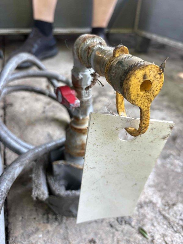 Responded to suspected gas leak at outdoor fireplace location. Performed leak detection using soap bubble solution on gas line connections and fittings. Confirmed active gas leak at corroded brass fitting showing significant oxidation and deterioration. Documented leak location with photos showing heavily corroded yellow-gold colored gas fitting with visible surface degradation. Provided estimate for repair of compromised gas line component to restore system integrity and eliminate safety hazard.