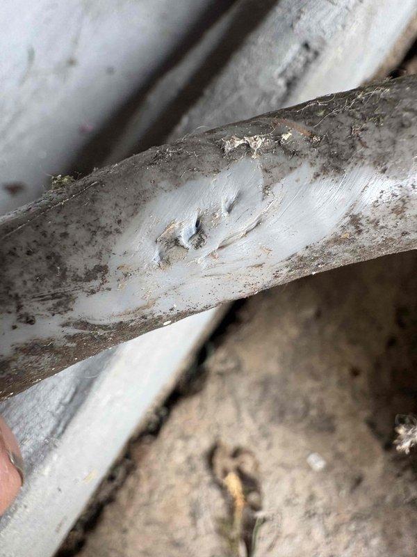 Responded to suspected gas leak at outdoor fireplace location. Performed leak detection using soap bubble solution on gas line connections and fittings. Confirmed active gas leak at corroded brass fitting showing significant oxidation and deterioration. Documented leak location with photos showing heavily corroded yellow-gold colored gas fitting with visible surface degradation. Provided estimate for repair of compromised gas line component to restore system integrity and eliminate safety hazard.