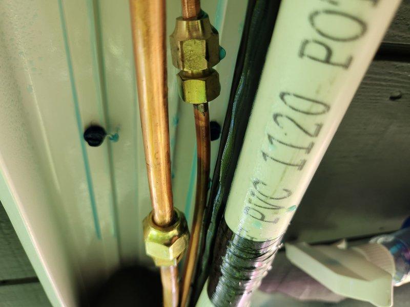 Completed mini split installation with proper refrigerant line connections using copper piping and brass compression fittings secured to the air handler unit. Verified level installation of exterior components and ensured all mechanical connections were properly assembled per manufacturer specifications.