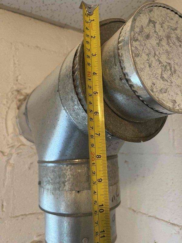 Conducted comprehensive assessment of existing ductwork system in commercial space for boiler heating distribution. Evaluated flexible aluminum duct installation running vertically along concrete block wall with elbow transition to ceiling plenum. Documented measurements of galvanized metal ductwork components, including 10-inch vertical section with elbow joint transitioning to horizontal run. Identified water damage in ceiling plenum affecting multiple acoustic tiles, indicating potential moisture infiltration requiring remediation. Assessed condition of sheet metal connections, fasteners, and overall duct integrity to provide accurate estimate for ductwork replacement or modification to support boiler heating system requirements.
