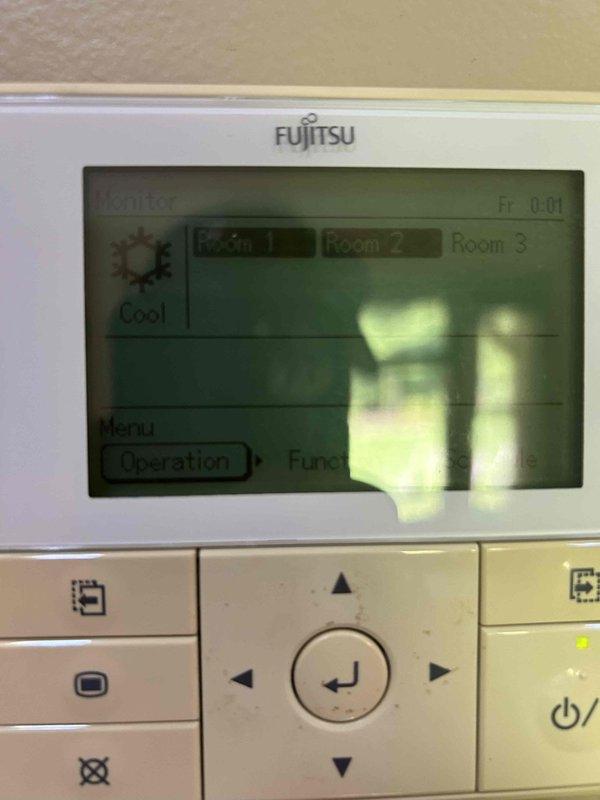 Responded to service call for non-operational Fujitsu mini-split system. Upon arrival, inspected both the indoor wall-mounted controller and outdoor condenser unit. Verified system status through the digital thermostat interface, which displayed cooling mode settings and multi-zone room configuration. Performed diagnostic evaluation of the outdoor Fujitsu condenser unit mounted on concrete block foundation, checking for proper power supply, refrigerant line connections, and component functionality. Restored system to proper working condition and confirmed operational status across all zones.
