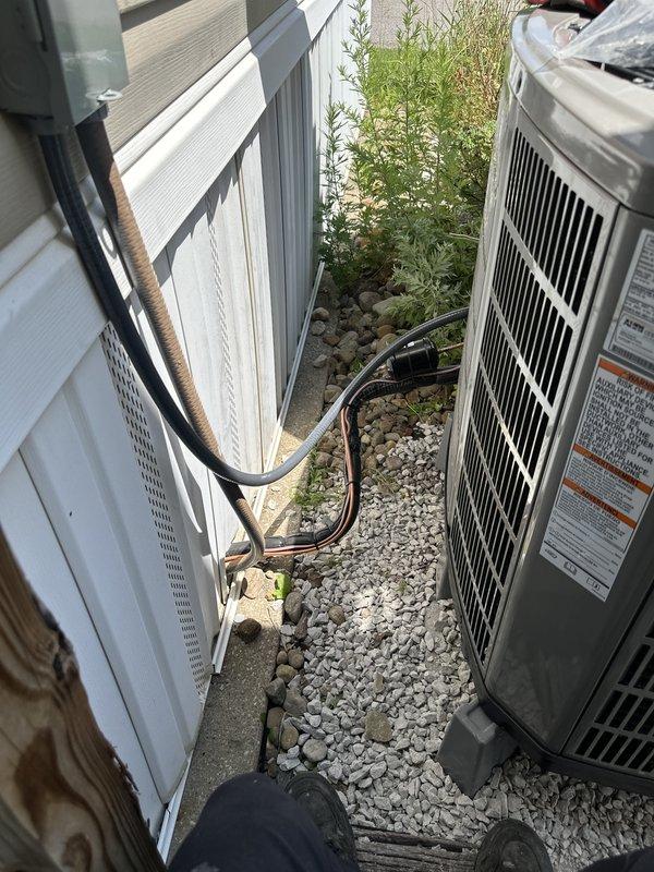 Completed full HVAC system installation including outdoor condensing unit with proper refrigerant line routing and leveling verification. Unit was positioned on gravel pad with adequate clearance for airflow and service access, electrical disconnect box mounted on exterior wall per code requirements, and all connections tested for proper operation prior to system activation.