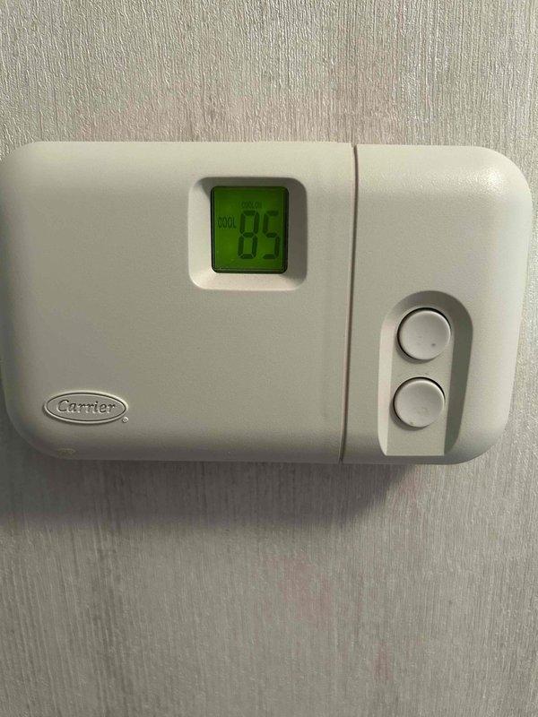 Responded to no-cooling complaint at residential property. Upon arrival, found Carrier thermostat displaying 84°F and calling for cooling. Inspected outdoor disconnect and found electrical connections in deteriorated condition with significant dust accumulation, corrosion, and evidence of moisture intrusion in junction box. Corroded terminal connections and degraded wiring identified as primary cause of system failure. Cleaned and tightened all electrical connections at disconnect, verified proper voltage supply to condensing unit, and confirmed system operation. Unit now cooling properly with thermostat responding to temperature setpoint adjustments.