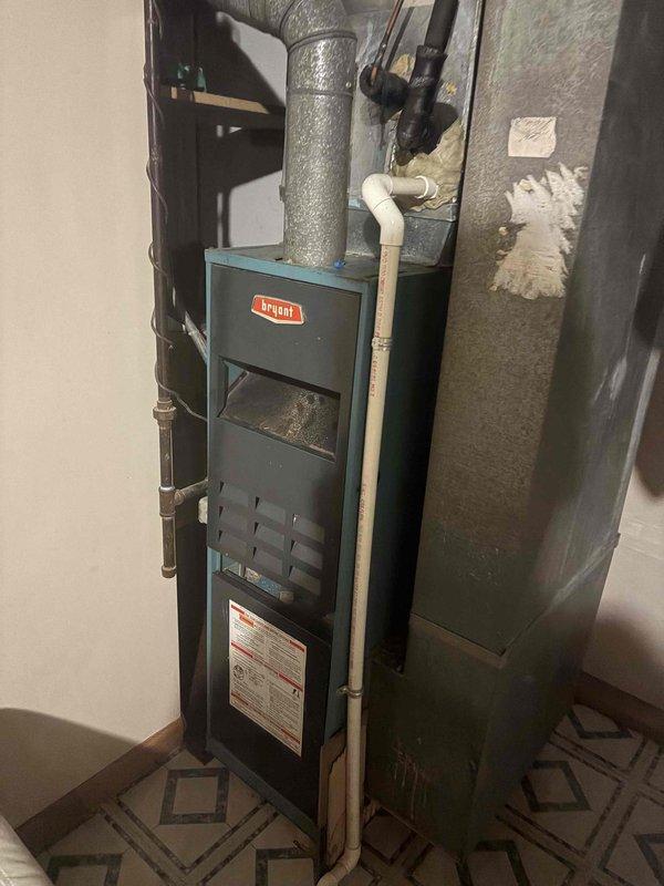 Responded to no cooling call on residential HVAC system over 10 years old. Upon inspection, found outdoor condenser coil heavily contaminated with dirt and debris buildup, restricting airflow and reducing heat transfer efficiency. Indoor Bryant furnace and ductwork appeared in serviceable condition. Documented equipment condition with photographs showing extent of coil contamination and overall system configuration. Customer approved cleaning and necessary repairs to restore cooling operation.