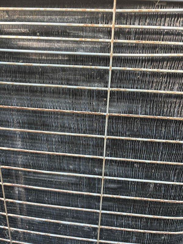 Responded to no cooling call on residential HVAC system over 10 years old. Upon inspection, found outdoor condenser coil heavily contaminated with dirt and debris buildup, restricting airflow and reducing heat transfer efficiency. Indoor Bryant furnace and ductwork appeared in serviceable condition. Documented equipment condition with photographs showing extent of coil contamination and overall system configuration. Customer approved cleaning and necessary repairs to restore cooling operation.