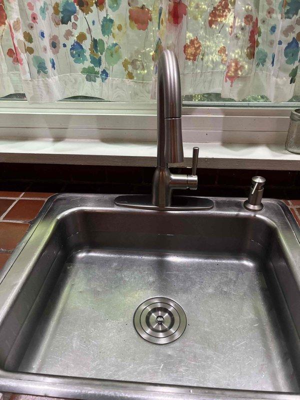 Responded to service call for leaking kitchen sink requiring faucet replacement. Inspected existing plumbing configuration including P-trap assembly, drain lines, and supply connections beneath sink. Removed old faucet assembly and installed new kitchen faucet with integrated pull-out sprayer attachment per customer specifications. Verified all supply line connections were secure, tested for leaks, and confirmed proper drainage and sprayer functionality upon completion.