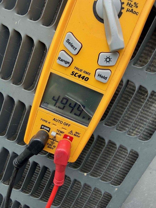 Completed cooling maintenance club visit on air handler unit. Performed comprehensive system inspection including electrical testing with digital multimeter, recording voltage reading of 49.42V. Verified proper operation of all components and documented equipment condition with exterior utility disconnect and air handler unit showing normal weathering consistent with outdoor installation.