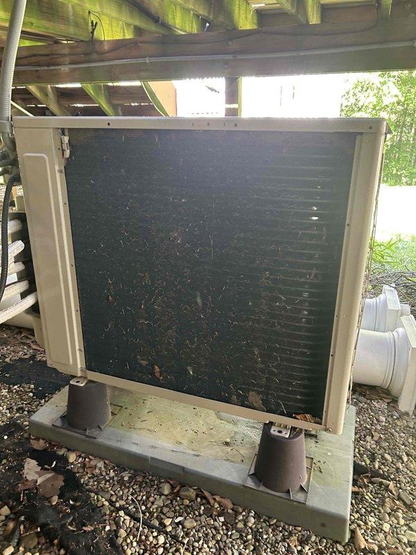Returned to site with diagnostic equipment to complete PCB board replacement on outdoor condensing unit. Previous appointment had been delayed due to vendor shipping issues with overnight parts delivery. Upon arrival, verified parts availability and completed installation of the printed circuit board. Unit was located beneath raised deck structure on gravel pad, with exterior coil showing heavy debris accumulation and significant soiling that would benefit from future maintenance cleaning to restore proper airflow and efficiency.