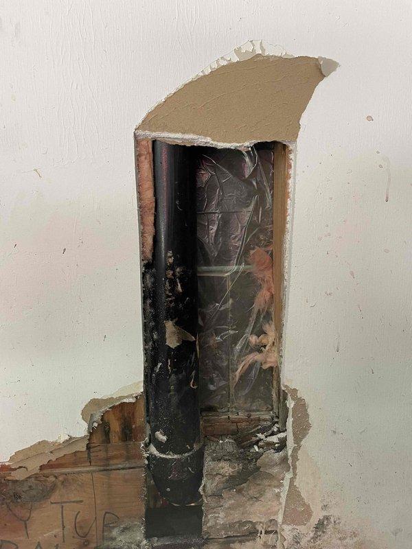 Responded to a leak at the garage sink. Upon investigation, accessed the wall cavity to locate the source of the water intrusion affecting the PVC drain line. Identified leak at pipe connection point, replaced damaged coupling bands, and secured the vertical drain pipe with new metal clamps. Verified proper drainage and confirmed leak was resolved. Wall opening left accessible for drying and future closure by property owner.