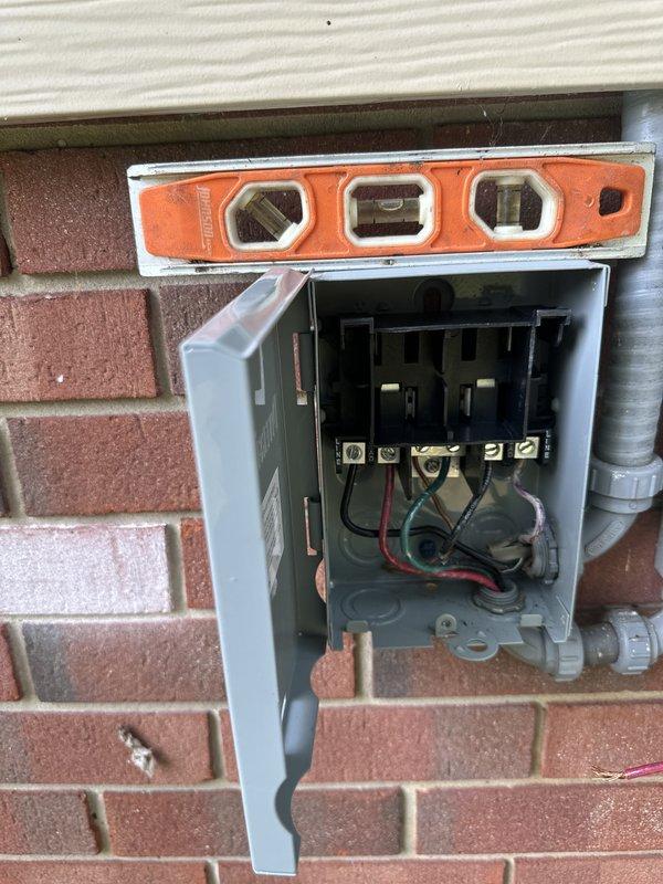 Completed full HVAC system installation as approved return visit. Installed new contactor with proper electrical connections, mounted and wired exterior disconnect box on brick wall exterior, and verified level installation of all components. All electrical connections secured with appropriate color-coded wiring (red, black, and green conductors). System tested and operational upon completion.