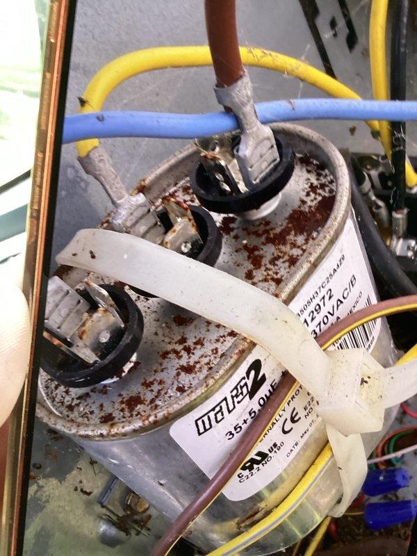 Completed cooling maintenance club visit on air handler system. Performed comprehensive electrical diagnostics using digital multimeter, recording voltage and amperage readings to verify proper system operation. Inspection revealed dual-rated capacitor (35/5 MFD, 370VAC) with significant rust and corrosion on cylindrical casing, though electrical terminals and connections remained intact. All electrical connections were tested and found secure. Documented equipment condition with photos for maintenance records. System operational at time of departure.