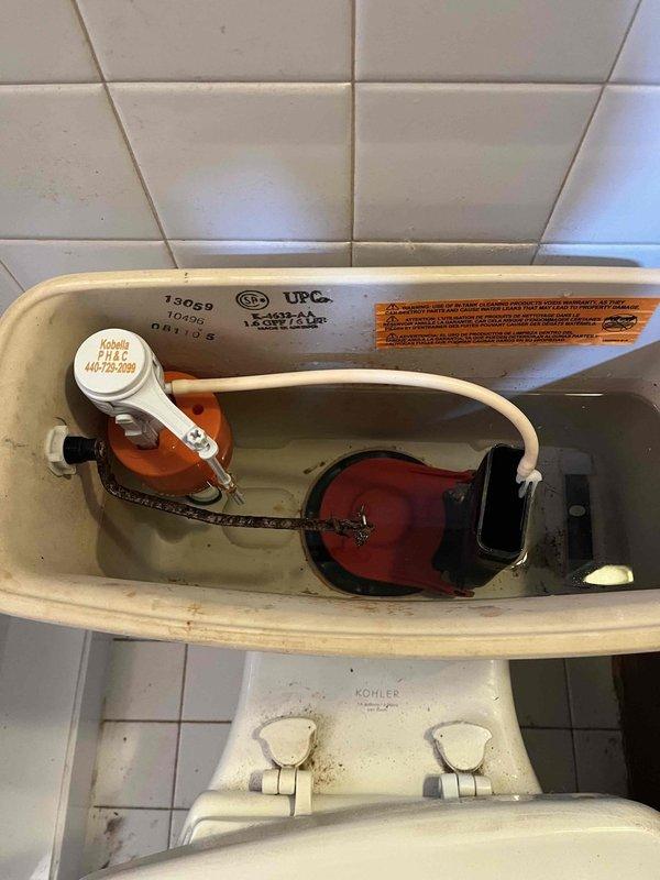 Responded to service call for malfunctioning toilet fill valve in a 10-year-old Kohler two-piece elongated toilet (model K-3551-0 or K-3487), chair height, 1.28 GPF with 10-inch deep tank. Upon inspection, confirmed the existing slider/piston style fill valve was not operating properly. Removed the defective fill valve assembly and installed a new replacement fill valve unit to restore proper tank filling function. Tested the toilet operation to ensure proper water level, fill cycle, and shut-off performance. System now functioning correctly with no leaks detected at supply line connections.