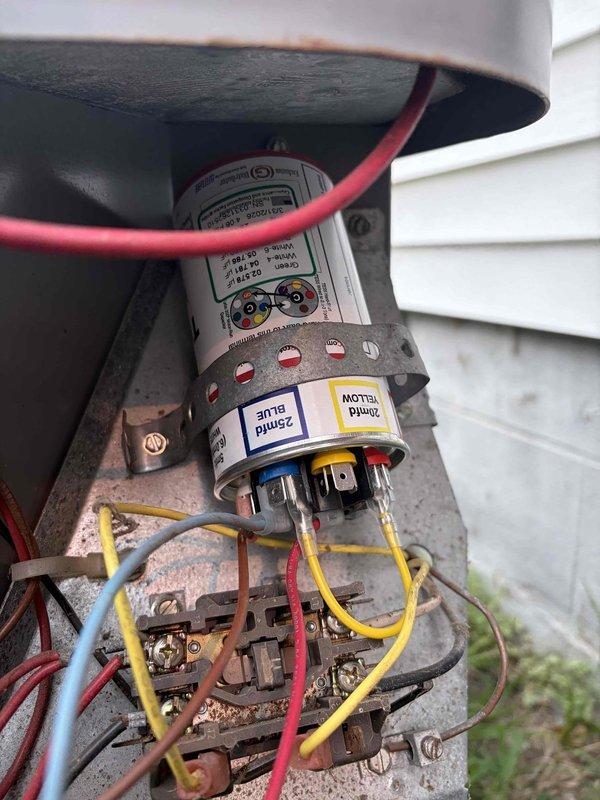 Responded to no-cool call on residential air conditioning system of unknown age. Upon inspection, found failed dual run capacitor with severe rust and corrosion on terminal connections. Capacitor showed signs of extended exposure to moisture and environmental degradation, causing complete system shutdown. Removed defective capacitor and installed new replacement unit with proper electrical connections. Verified all wire terminations were secure and tested system operation. Unit successfully powered on with compressor and condenser fan motor running properly. System returned to normal cooling operation.
