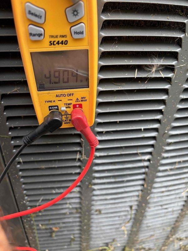 Completed club membership renewal service and performed routine HVAC air handler maintenance inspection. Conducted operational diagnostics using digital multimeter, recording temperature readings of 38.3°C and voltage measurements of 490.7V to verify system performance parameters. Documented equipment condition with photographic evidence showing coil surfaces with moderate dust and debris accumulation between fins, consistent with normal outdoor unit exposure.