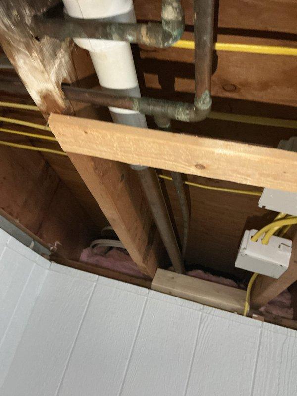 Inspected sewer line system in ceiling cavity and documented existing plumbing configuration to assess drainage concerns. Photographed white PVC drain piping showing visible sagging and improper slope, identified as a belly condition that could lead to waste accumulation and blockages. Provided customer with multiple remediation options including pipe rerouting, support installation, or full section replacement to restore proper drainage gradient and prevent future system failures.