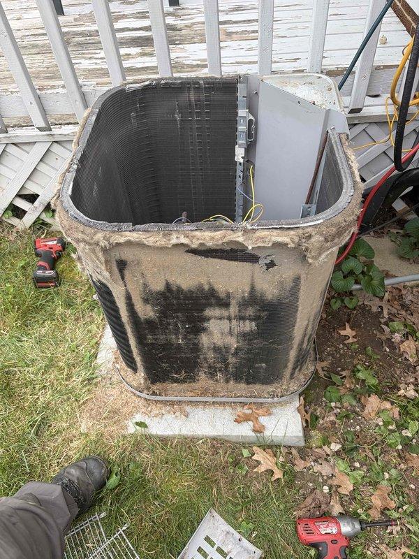 # HVAC Service Completion

Responded to no cooling complaint on aging residential air conditioning system. Upon arrival, performed visual inspection of outdoor condenser unit which showed significant dirt accumulation and external soiling on cabinet panels. Removed top access panel and side service panel to access internal components for diagnostic evaluation.

Conducted thorough assessment of condenser coil, refrigerant lines, and electrical connections. Condenser coil displayed heavy dirt and debris buildup between fins, restricting airflow and reducing heat transfer efficiency. Inspected refrigerant line insulation on both liquid and suction lines - found insulation intact with proper securing. Verified electrical disconnect box operational and properly mounted.

Unit exhibited typical wear patterns consistent with 10+ years of outdoor exposure including weathered cabinet finish and accumulated environmental contamination. Internal components accessible for service with standard ref
