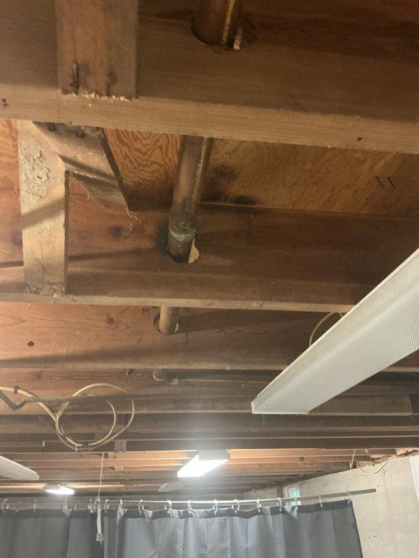 Responded to basement water leak emergency involving copper supply lines. Upon inspection, identified active leaks at pipe penetrations through floor joists in unfinished basement ceiling area. Secured leaking sections, assessed pipe condition showing age-related corrosion and wear, and recommended permanent repairs to prevent water damage. Documented existing plumbing configuration and structural penetrations for follow-up work.
