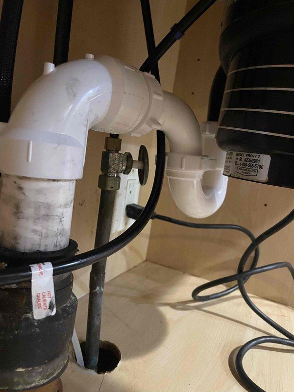 Responded to clogged kitchen sink complaint and performed diagnostic inspection of drainage system. Upon examination of under-sink plumbing, identified blockage in P-trap assembly connected to garbage disposal unit. Disassembled P-trap components, cleared accumulated food debris and grease buildup causing obstruction, and reassembled drainage piping. Tested water flow through system to verify proper drainage function and confirmed no leaks at connection points.