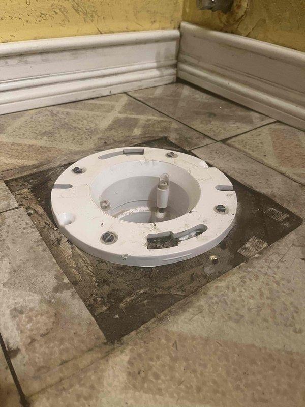 Completed follow-up plumbing service for previously sold jetting work. Inspected toilet flange installation in tiled bathroom floor and examined internal tank components including fill valve with float assembly and overflow tube connection. Documented existing conditions showing worn flooring around fixture and mineral staining in tank interior to verify system functionality after jetting service.