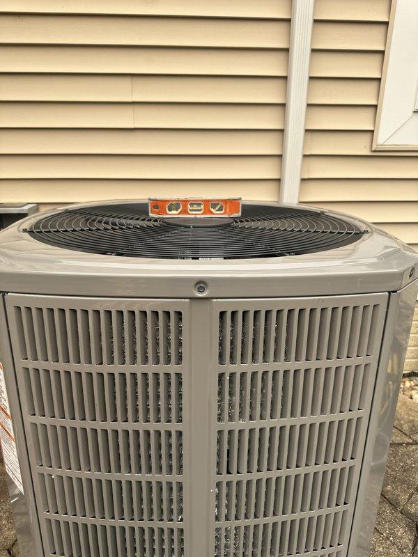 Completed full HVAC system installation including outdoor condensing unit and electrical service components. Verified proper unit leveling and secured all electrical connections at junction box with appropriate circuit protection. System positioned on concrete pad against building exterior with PVC line set installation and proper clearances maintained per manufacturer specifications.