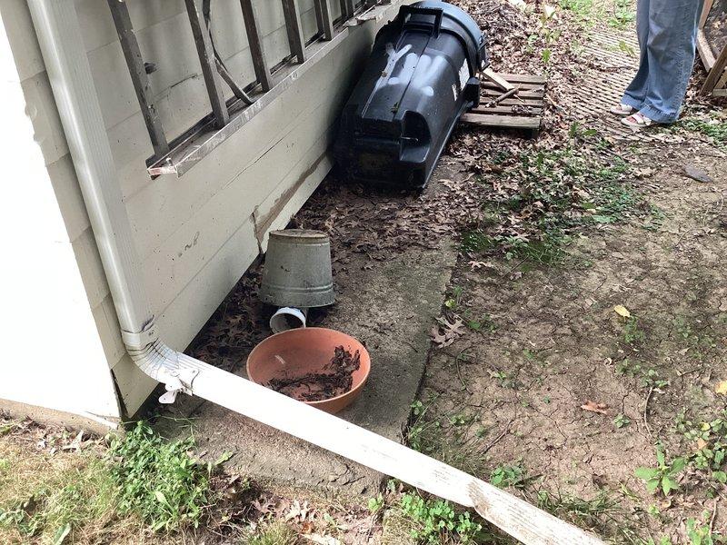 Conducted site assessment for ductless mini-split installation at residential property with no existing AC equipment. Evaluated exterior mounting location adjacent to building foundation and interior garage/basement area with exposed ceiling joists to determine optimal placement for outdoor condenser unit and indoor air handler, documenting conditions and measuring spaces for equipment specifications and refrigerant line routing.