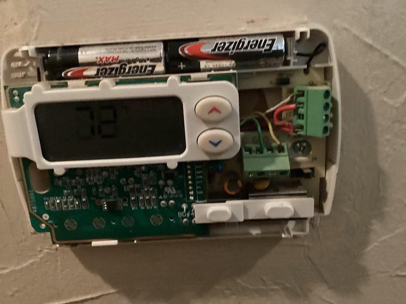 Conducted comprehensive assessment of existing residential HVAC system in basement mechanical room. Evaluated beige furnace unit with copper refrigerant lines and associated ductwork for replacement needs. Inspected wall-mounted programmable thermostat with exposed internal components, including circuit board, wiring connections, and battery compartment. Documented current system configuration including air handler, metal ductwork, and refrigerant line routing. Prepared detailed estimate for complete air conditioning system replacement based on equipment age, condition, and operational deficiencies identified during inspection.
