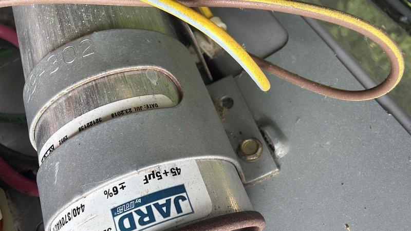 Completed prepaid club maintenance visit on air handler unit. Inspected dual-run capacitor rated at 45+5 MFD 440/370 VAC, confirmed secure mounting and proper wire connections. Performed voltage testing with digital multimeter, recording 495 volts during diagnostic procedures to verify electrical system operation and component functionality.