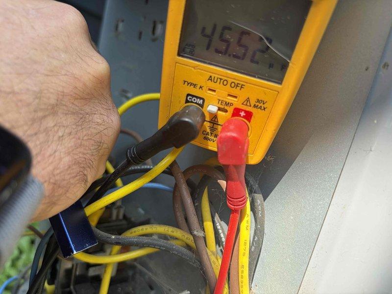 Completed prepaid club maintenance visit on air handler unit. Inspected dual-run capacitor rated at 45+5 MFD 440/370 VAC, confirmed secure mounting and proper wire connections. Performed voltage testing with digital multimeter, recording 495 volts during diagnostic procedures to verify electrical system operation and component functionality.