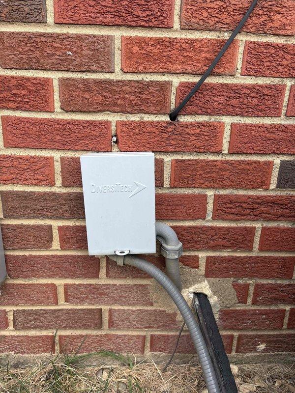 Conducted on-site evaluation for air conditioning system replacement. Assessed existing thermostat wiring configuration, documenting multi-stage heat pump setup with Y, Y2, G, C, and Rc connections at wall-mounted base plate. Inspected exterior electrical disconnect and line set penetration point on building exterior, verifying conduit routing and junction box placement. Provided customer with equipment replacement options and system upgrade recommendations based on current installation configuration.
