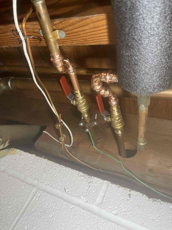 Completed return visit for previously sold plumbing repair work. Installed new copper supply line assembly with brass compression fittings and red-handled ball valves in attic space, ensuring proper connections to existing HVAC ductwork and structural framing. Additionally, replaced under-sink drainage system with new white PVC P-trap assembly and tailpiece, along with braided stainless steel flexible supply line installation, verifying all connections are secure and leak-free.