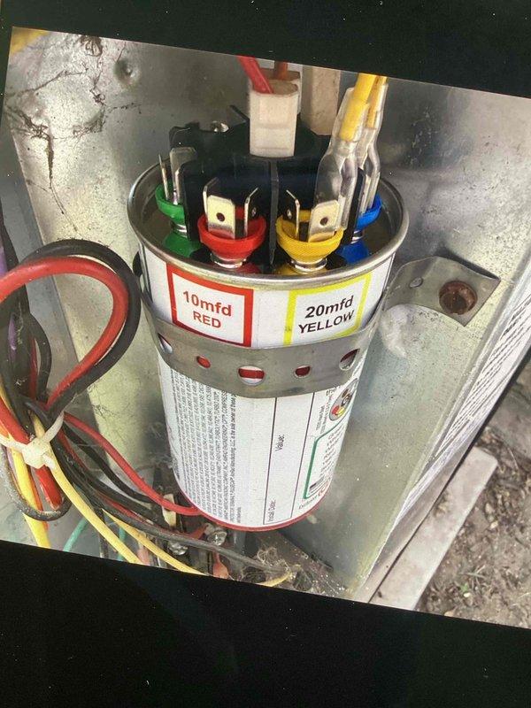 Responded to no cooling call on residential air conditioning system blowing lukewarm air. Upon arrival, found extensive contamination and debris accumulation throughout the electrical compartment, including fibrous material and dust buildup around the dual-run capacitor and wiring connections. Inspected capacitor connections and found deteriorated conditions with visible staining around terminal points. Cleaned electrical compartment, removed accumulated debris, and verified proper capacitor operation and wire connections. System restored to normal cooling operation.