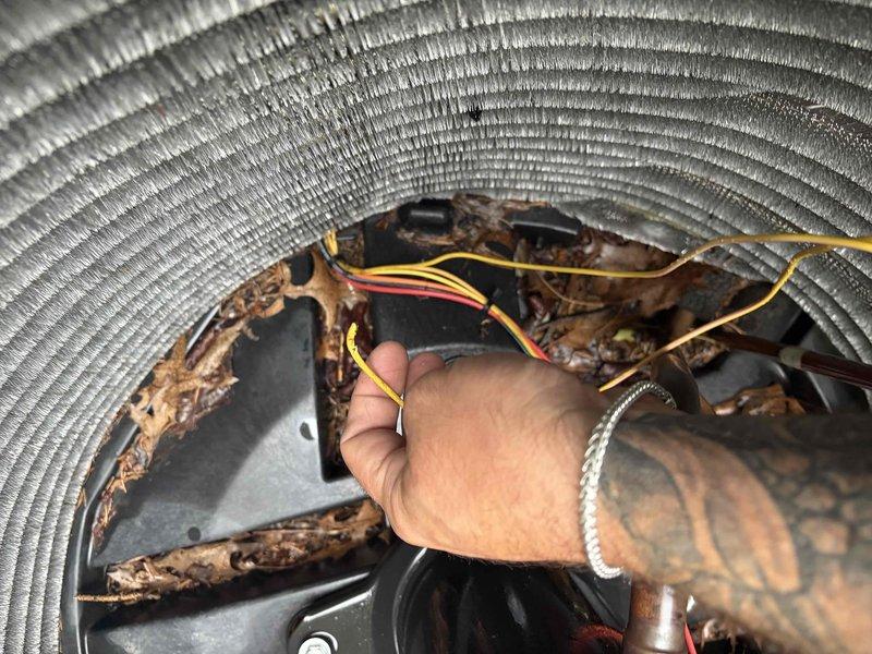 Responded to service call for potential refrigerant charge on a two-year-old air conditioning system. Upon arrival, performed visual inspection of outdoor condensing unit and accessed internal components to assess system condition. Found significant deterioration of interior surfaces with extensive coating failure, moisture damage, and corrosion present on metal panels and blower housing. Observed white residue deposits indicating possible moisture intrusion or chemical breakdown. Inspected electrical connections and wiring routing through equipment housing—all connections appeared intact and properly secured despite environmental degradation of surrounding surfaces. The advanced deterioration level is unusual for a unit of this age and suggests ongoing moisture exposure or installation issues requiring further investigation. Documented equipment condition with photographic evidence showing corroded components, debris accumulation, and compromised protective coatings. Recommend compreh