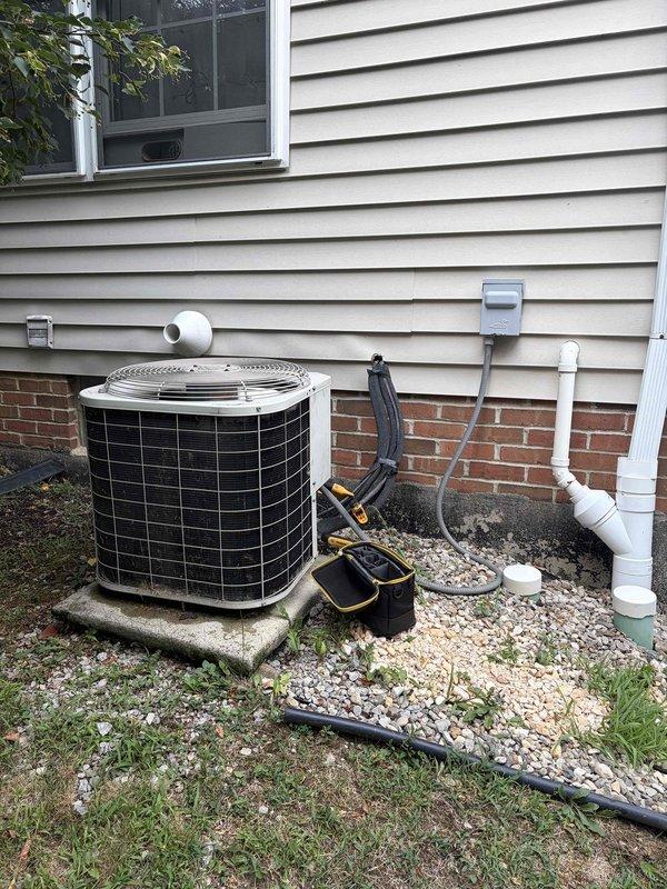 Responded to no cooling complaint on 10+ year old system with freezing conditions on both indoor evaporator coil and outdoor refrigerant lines. Upon arrival, confirmed system had been shut down overnight due to icing issue. Inspected outdoor condenser unit and indoor furnace/air handler assembly, documenting equipment condition with photographs. System exhibited classic symptoms of restricted airflow or low refrigerant charge causing freeze-up on suction and liquid lines. Customer has previously approved estimate to replace faulty AC disconnect, which remains pending installation and may be contributing to electrical issues affecting system performance.