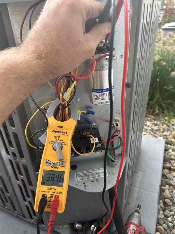# HVAC No Cooling Diagnosis - Outdoor Unit Short Cycling

Responded to no cooling complaint with outdoor unit cycling every 30 seconds and condenser fan failing to operate. Indoor blower was running continuously but delivering only ambient temperature air at registers. Upon arrival, confirmed outdoor unit was short cycling with condenser fan motor not engaging during compressor operation.

Performed electrical diagnostics on outdoor unit using digital multimeter. Removed access panel and tested capacitor, which displayed a reading of 38.96 microfarads. Inspected all electrical connections including contactor, capacitor, and wire terminations within the unit. Evaluated condition of dual run capacitor serving both compressor and condenser fan motor circuits.

Based on testing results and symptom presentation, determined capacitor was significantly underperforming specifications, preventing condenser fan motor from starting and causing compressor to cycle on thermal overload protection. V