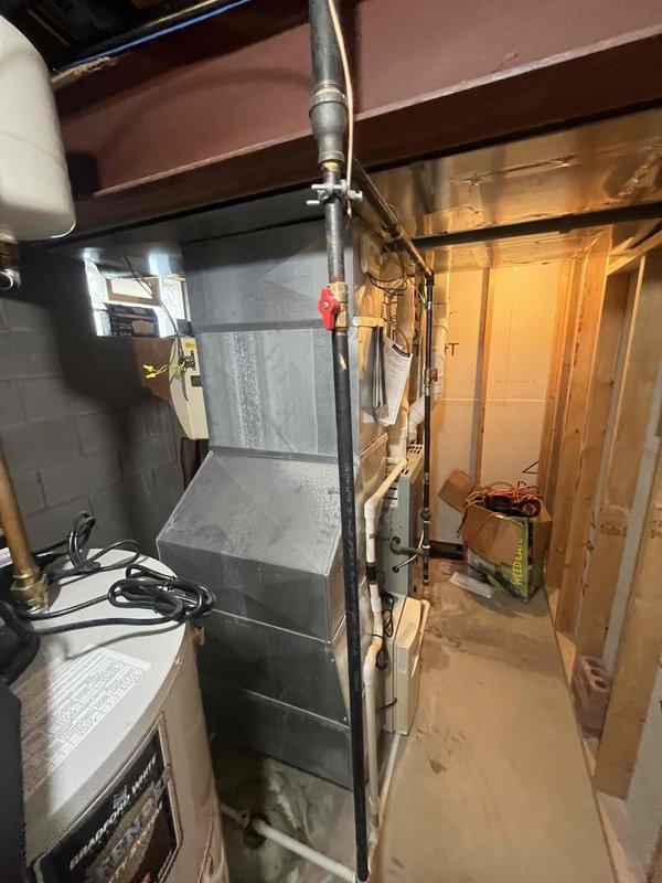 Responded to a flipped lead for an air conditioning system experiencing freezing on both indoor and outdoor refrigerant lines. System had been shut down since the previous night. Performed diagnostic assessment and provided estimate for complete HVAC system replacement. Documented existing equipment configuration including furnace and ductwork in basement utility area. Customer has previously approved estimate for AC disconnect replacement, which remains pending scheduling.