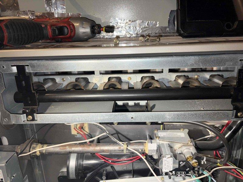 Responded to service call for AC blower motor failure with error code 41 displayed on 10-year-old air conditioning system. Upon inspection, confirmed blower motor had failed and determined motor does not utilize a capacitor. Accessed furnace cabinet to examine blower assembly and electrical connections. Diagnosed motor failure as root cause of system malfunction. Reviewed control board and wiring connections, verified gas furnace burner assembly and associated components for safe operation during inspection. Documented equipment condition with photographs showing internal components, burner assembly, gas valve, control module, and GE IsoflexXL control device with toggle switches. Provided customer with assessment and recommendations for blower motor replacement to restore cooling system operation.