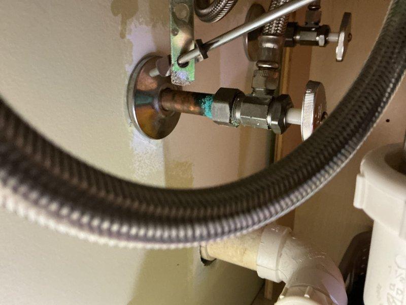 Completed comprehensive plumbing inspection addressing two primary concerns. Adjusted water pressure at kitchen sink to restore proper flow rate. Repaired leaking hot water handle in master bathroom, which involved servicing corroded valve assembly showing significant oxidation and mineral deposits on copper connections and fittings beneath the sink.
