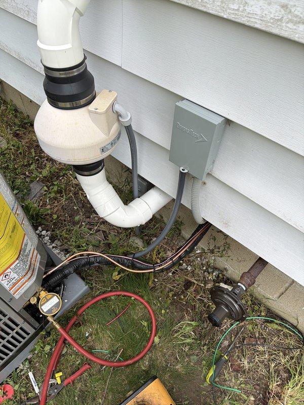 Completed full HVAC system installation including outdoor condensing unit, refrigerant line set, electrical disconnect with fuse protection, and condensate drainage system. Installed PVC drain piping with proper coupling and support, ran copper refrigerant lines with insulation, established electrical service with junction box and conduit, and performed system startup with refrigerant charging and pressure testing to verify proper operation.