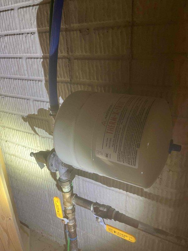 Responded to complaint of inconsistent water pressure after water department had already investigated. Inspected pressure reducing valve (PRV) and associated plumbing system to diagnose malfunction. Evaluated expansion tank installation, shut-off valves, and piping connections in basement utility area. Confirmed PRV failure was causing erratic water pressure throughout residence. Documented existing system configuration including copper piping, brass fittings, and expansion tank setup for service records.
