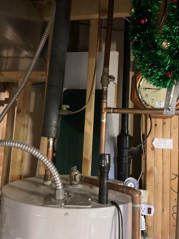 Performed assessment of existing 50-gallon electric water heater in basement utility area. Customer requested conversion from electric to gas water heater system. Documented current installation including copper supply lines, expansion tank, electrical connections, and surrounding plumbing infrastructure. Photographed existing equipment and utility space configuration to prepare for future gas water heater installation and necessary modifications to accommodate gas supply line, venting requirements, and updated connections.