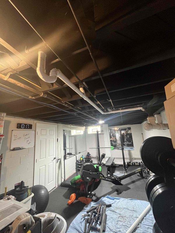 Responded to water leak originating from shower area affecting basement ceiling and home gym space below. Upon inspection, identified compromised plumbing connections in exposed ceiling piping system above workout area. Located source of leak in shower drain assembly with visible water damage to surrounding pipe connections and ceiling joists. Repaired faulty connections, sealed affected areas, and verified system integrity through pressure testing to ensure no further water intrusion into basement space.