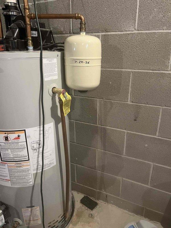 Conducted estimate for replacement of 10-year-old Bradford White RG1PV50S6N 50-gallon natural gas power-vent water heater located in basement. Inspected existing unit and documented configuration including expansion tank dated 2-24-26, copper supply piping, brass fittings, and circulation pump connections. Observed significant corrosion and deterioration on power-vent exhaust piping requiring replacement. Provided pricing options for comparable or upgraded 50-gallon power-vent unit including removal and disposal of existing water heater, installation of new unit with code-compliant venting system, and transfer of existing expansion tank and plumbing connections.
