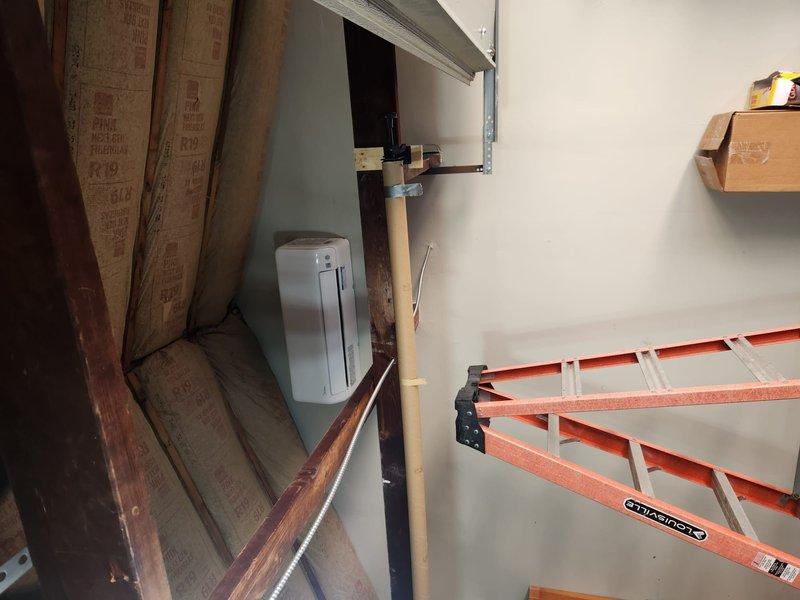 Completed mini split installation in interior space under renovation. Installed indoor air handler unit with mounting bracket on upper wall section, ran refrigerant lines and electrical connections through framing, and positioned outdoor condenser unit on exterior deck area. System tested and verified operational upon completion.