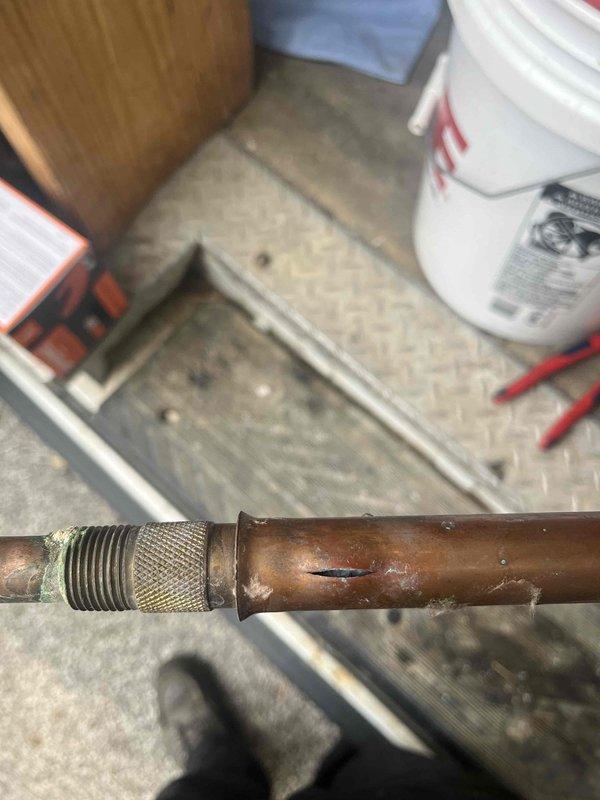 Responded to a leak at an outdoor spigot that was causing water intrusion into the basement. Upon inspection, identified a corroded copper pipe connection with a compromised threaded brass fitting showing significant oxidation and age-related deterioration. Repaired the failed connection point to eliminate the leak and prevent further water damage to the basement area.