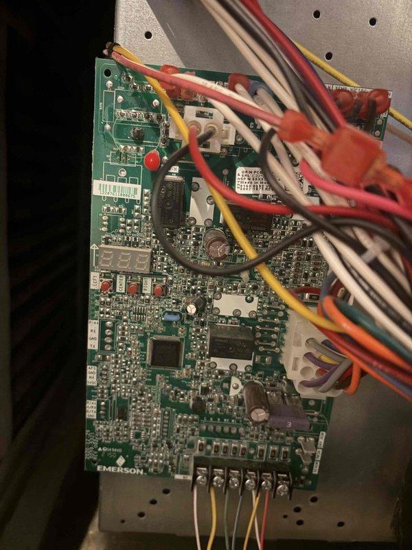Completed routine cooling maintenance on air handler unit. Inspected and photographed Emerson control board showing all electronic components, indicator lights, and wiring connections in proper working condition. Verified outdoor disconnect and electrical connections at exterior receptacle.